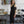 Charger l&#39;image dans la galerie, young woman standing in fashion studio wearing a Black one-shoulder tank top, with a band that crosses over the chest and arm. Design by Alex Watson Studio.
